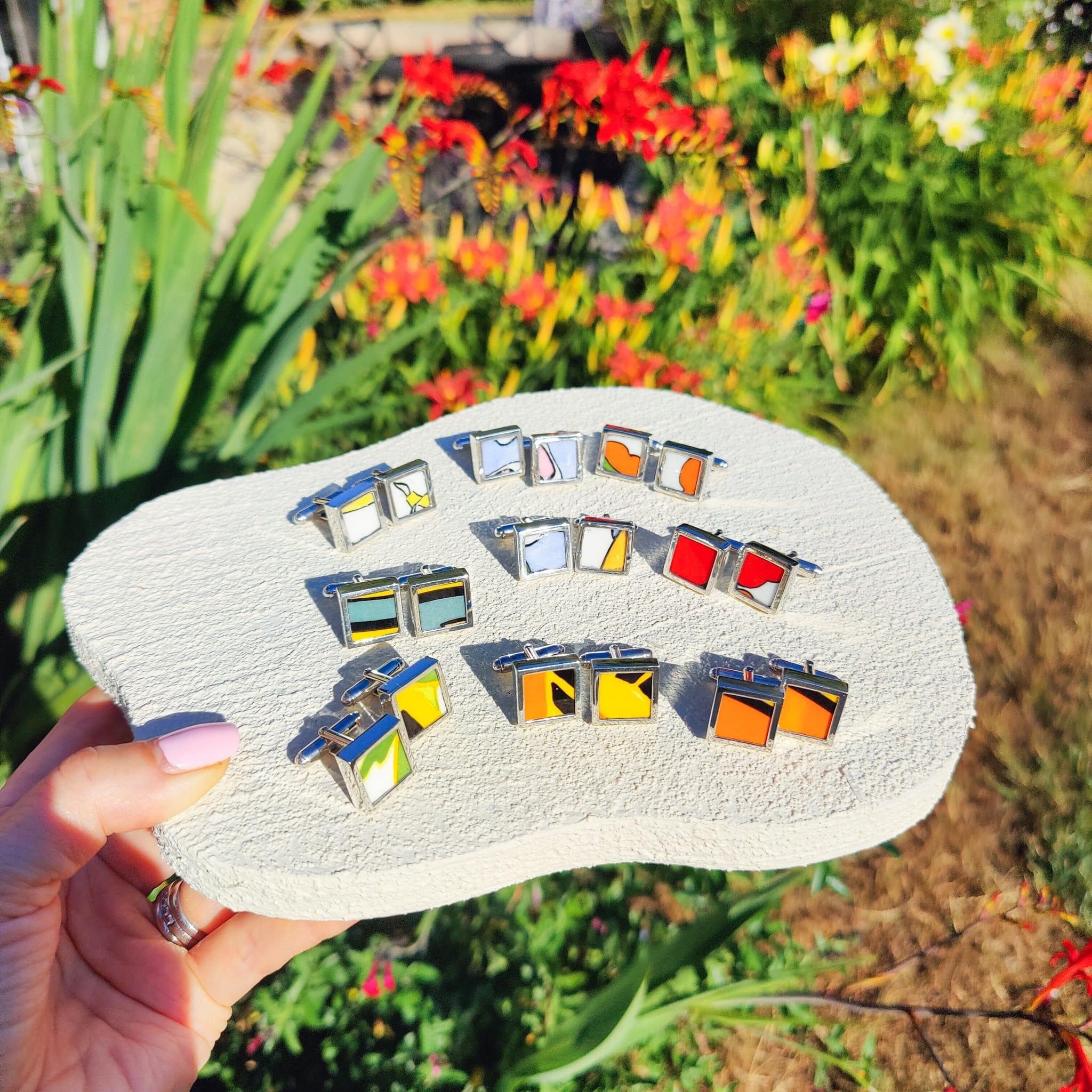 A collection of Clarice Cliff cufflinks, made from fragments of Clarice Cliff pottery from Stoke-on-Trent