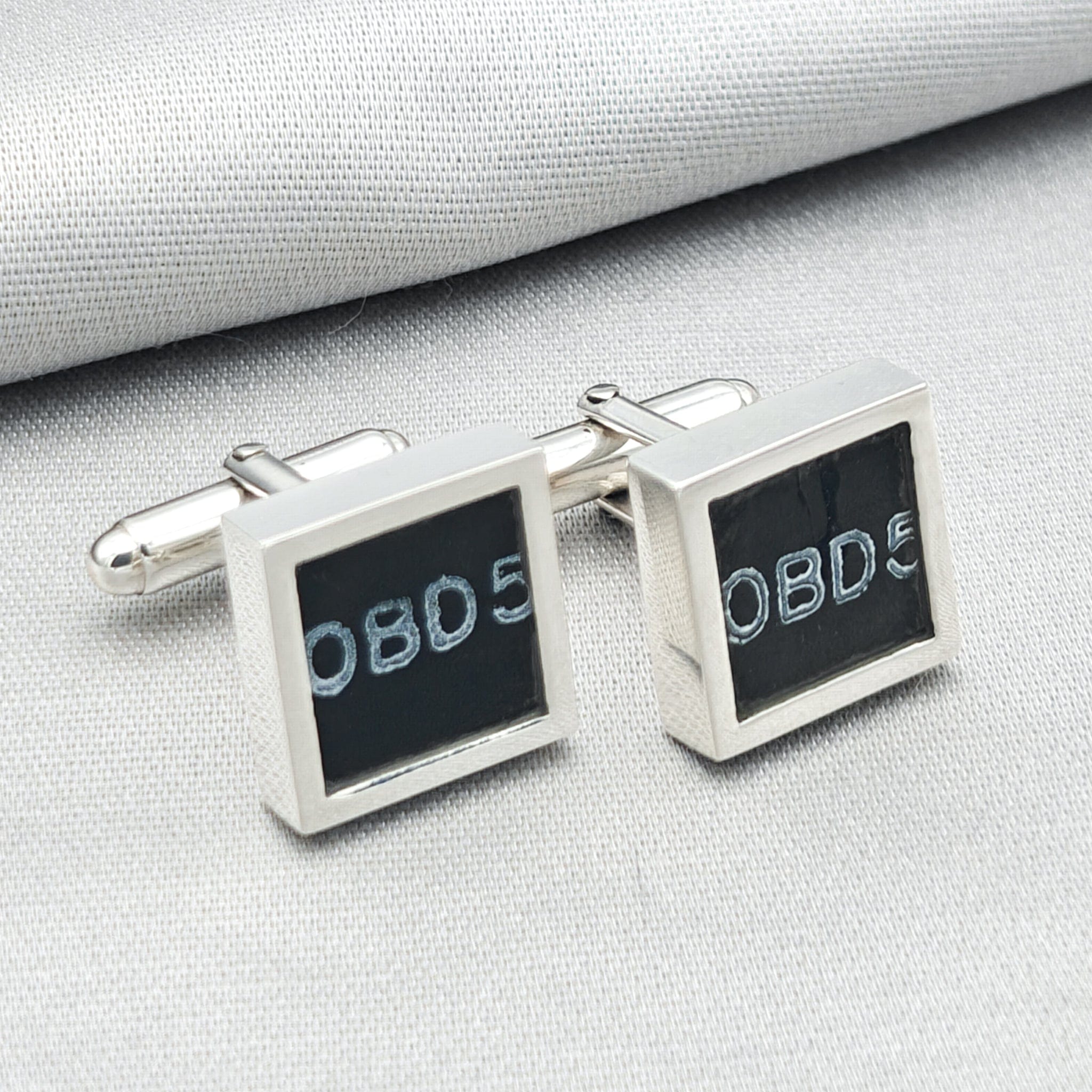 chinook cufflinks on pale background with OBD text visible from instrument panel