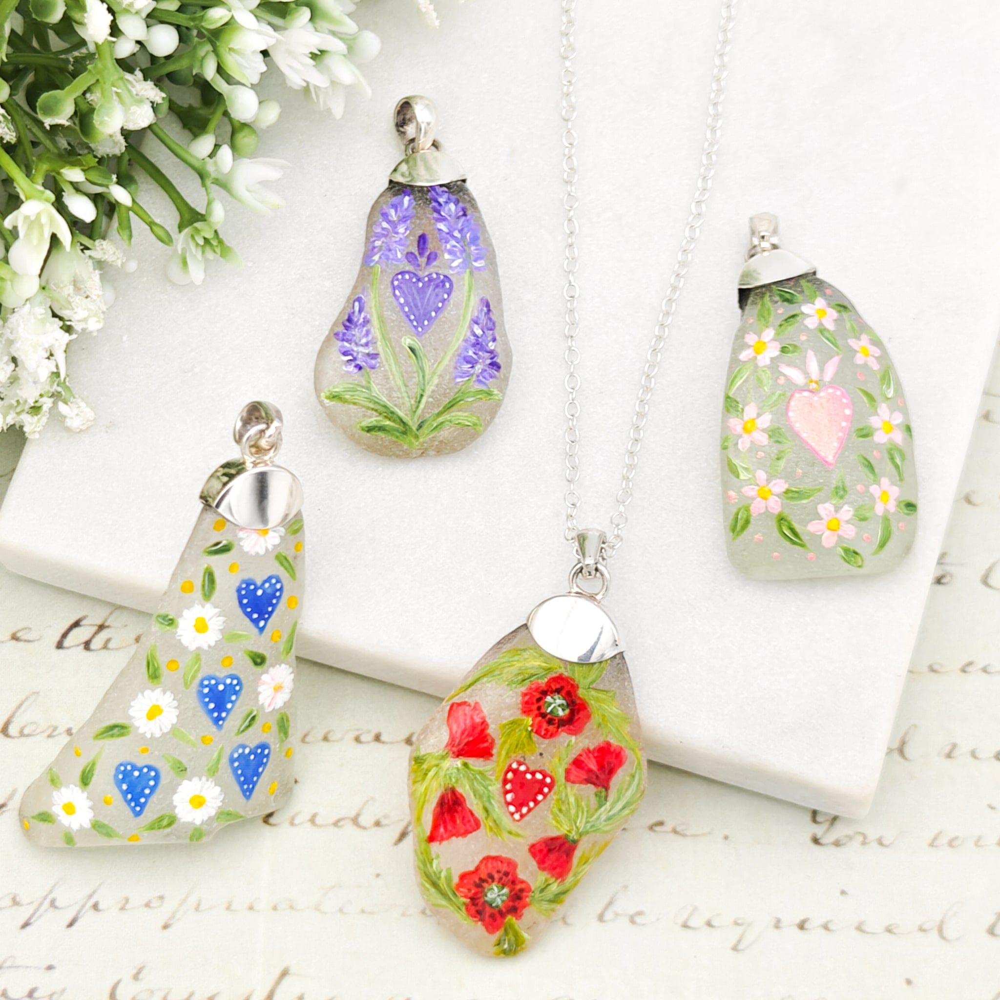 Sea glass pendants with hand-painted flowers and hearts