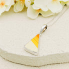 Clarice Cliff pendant with White, orange and yellow stripes -original Clarice cliff pottery. It's on a pale stone background with white orchids behind